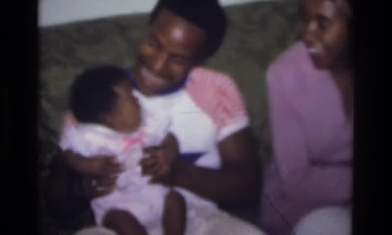 1975: Atlanta Georgia, USA. A Man Sitting On A Couch Holding A Baby.