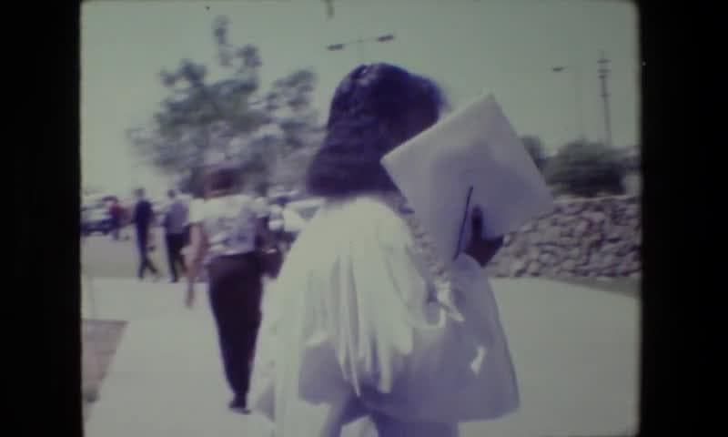 1983: Lansing Michigan. Women Student Graduation Ceremony Walking Away.