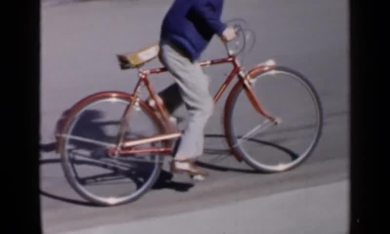 1957: Birmingham Alabama. A Man Riding A Bike Down A Street.