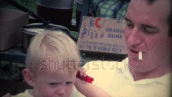 Retro clip of a dad smoking while holding a baby.