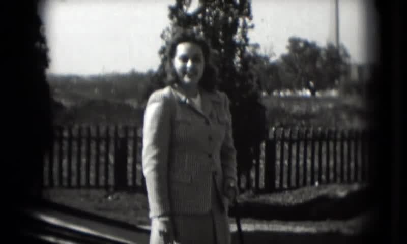 1946: Washington DC Visit. A Black And White Photo Of A Woman Standing In Front Of A Fence.
