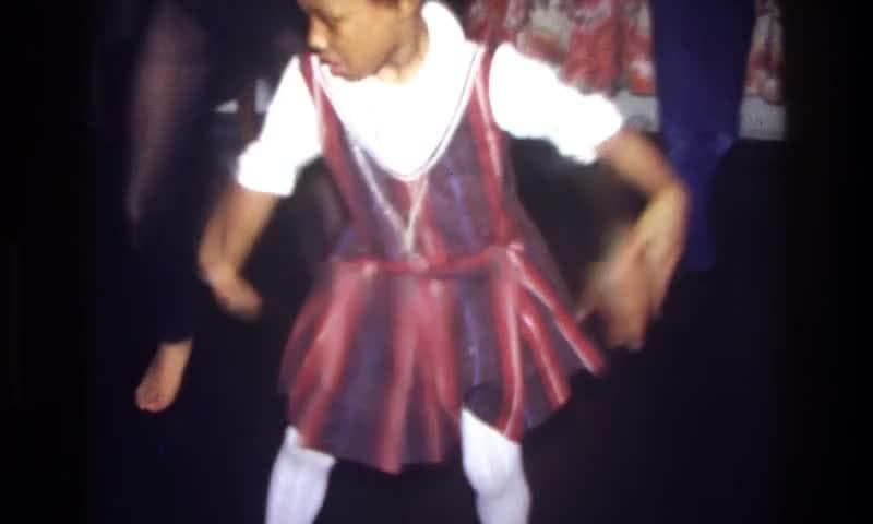 1975: Bronx, New York, USA. A Little Girl In A Red And Purple Dress.