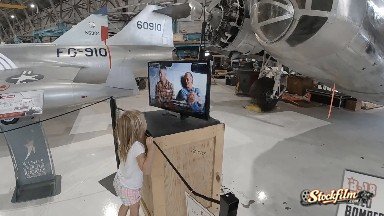 Young Girl Watching Video Interview in Airplane Museum. Denver, Colorado.
