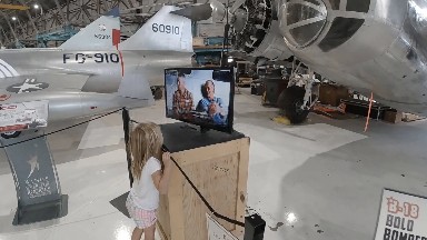 Young girl watching video interview in airplane museum. Denver, Colorado.