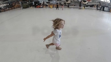 Toddler Girl Running Inside Building With White Floor. Denver, Colorado.