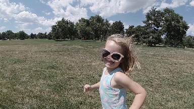 Girl In Sunglasses Running In A Field With A Kite