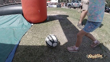 Little Kid Kicking Soccer Ball at Carnival. Denver, Colorado.