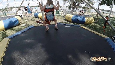 Girl Landing On Inflatable Jumper At Park. Denver, Colorado.