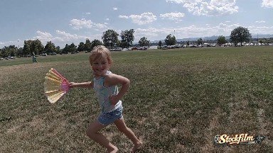 Young Girl Running With Fan In Her Hand. Denver, Colorado.