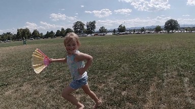Young Girl Running With Fan In Her Hand. Denver, Colorado.