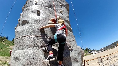 Woman Climbing On A Rock Wall With A Rope