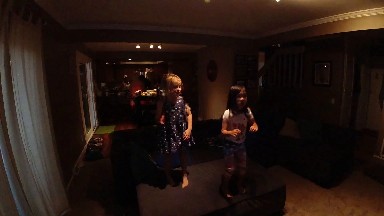 Two Children Standing In A Living Room Together