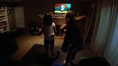 Two Girls Playing A Video Game In The Living Room