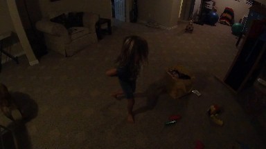 Little Girl Standing In A Living Room With A Bag