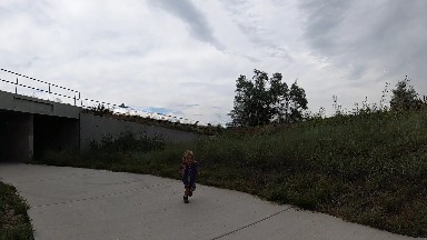 Young Girl Riding A Skateboard Down A Sidewalk