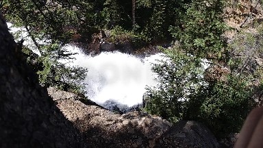 Person Standing On A Rock Looking At A Waterfall