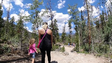 Woman And A Child Walking Down A Dirt Road