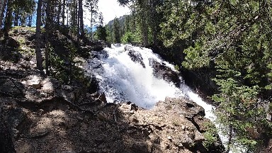 Waterfall That Is Flowing Down A Hill In The Woods