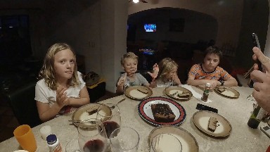 A Lot Of Children Sitting At A Table Eating Cake