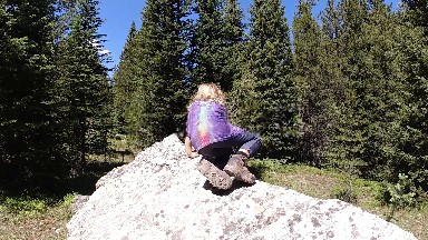 Woman Sitting On A Rock In The Woods