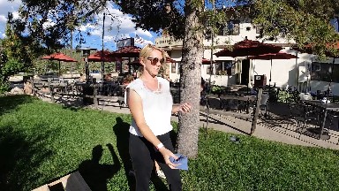 Woman Standing In Front Of A Tree With A Frisbee In Her Hand