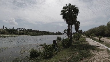 Man Riding A Bike Down A Path Next To A River