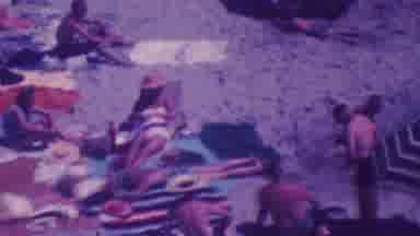 Palm Springs California USA-1964: A Large Group Of People Sitting On The Beach With Helicopter In Sky
