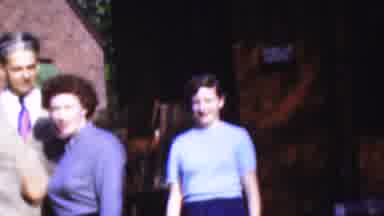 Wisconsin USA (1954): Two Women Walking To Pose Near A Man In Front Of A Building