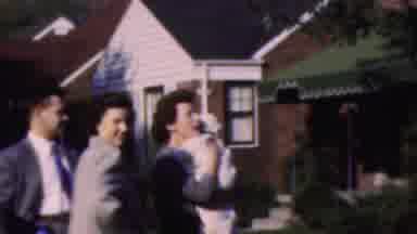Wisconsin USA (1954): Mom Soothing A Baby While Other Individuals Are Close To