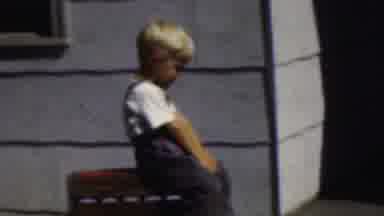 Wisconsin USA (1954): Toddler Boy Sitting Waving And Blowing Kisses Outside