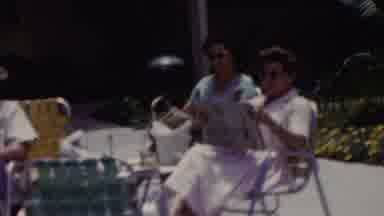 California USA (1961): Two Women Reading Newspapers While Sitting In Lawn Chairs