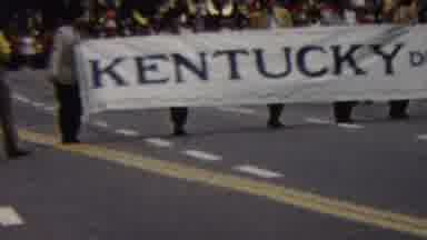 California USA (1961): People Walking In A Parade Are Carrying A Banner