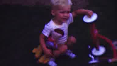 CLEVELAND OHIO USA-1953: A Blonde Boy Playing With His Tricycle In A Sunny Backyard