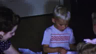 Columbus Ohio USA (1954): Child Sitting On The Floor Opening A Gift With Two Other