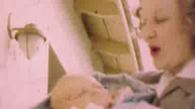 San Diego California USA (1955): Woman Holding And Rocking A Baby While Talking To