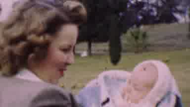 San Diego California USA (1955): Woman Holding Talking Singing Baby In Park