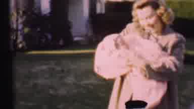 San Diego California USA-1955: Blonde Woman Cradling Newborn Baby in Yard