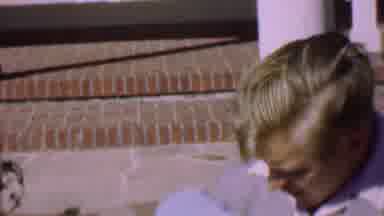 San Diego California USA (1955): A Man Sitting On The Curb Outside Holding His