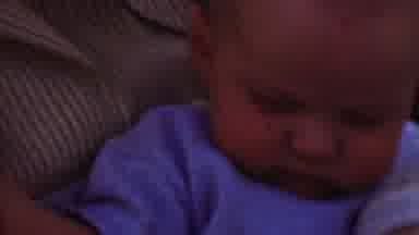 San Diego California USA (1955): Baby With Purple Shirt Laying On A Striped