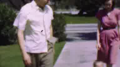 San Diego California USA (1955): Todler Runs Between A Man And Woman Walking On A