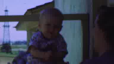 San Diego California USA (1955): Contented Chubby Baby Being Held By Older Woman
