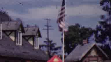 SOLVANG CALIFORNIA USA-1955: Danish and American Flags Flowing in Scenic Town Setting