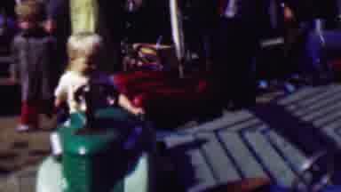 Terra Haute Indiana USA (1963): Blonde-Haired Child Riding Amusement Park Car.