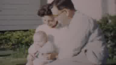 Lincoln Nebraska USA (1962): Baby Holding A Rattle And Sitting With Parents.