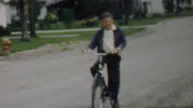 Louisiana USA (1959): Young Male Coasting While Riding Bike Followed By View Of