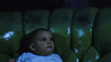 Omaha Nebraska USA (1959): A Baby Sits And Fidgets In A Green Upholstered Chair