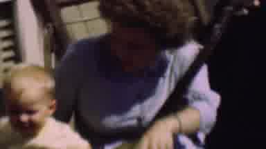 San Diego California USA (1961): Mother And Child Sit Together With A Stringed