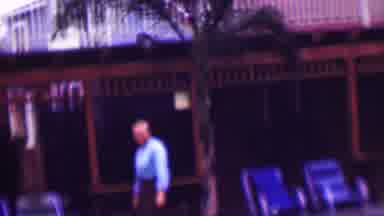 San Diego California USA-1961: Man In Blue Shirt Walks Past Open Air Porch