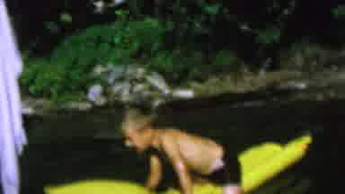 ST PAUL MINNESOTA USA-1962: A Boy Floats And A Girl Swims In An Outdoor Body Of Water