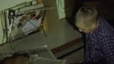 St Paul Minnesota USA (1962): Boy Plays With Puppy On Floor With Newspaper And